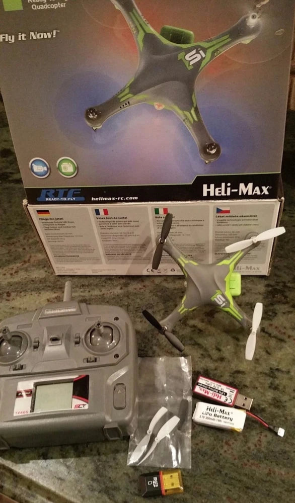 Ready-to-fly quadcopter drone kit with green-and-white drone, controller, battery, manuals