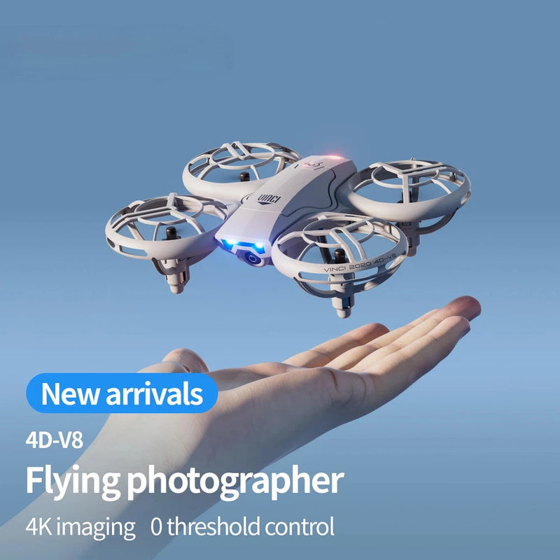 White mini quadcopter drone with four rotors, camera pod, hovering above a hand