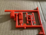 Red plastic model battery parts on sprue frame