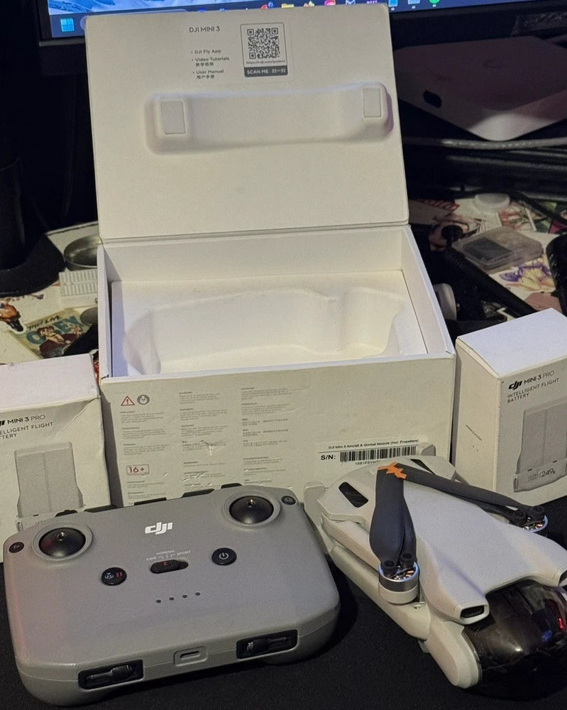 Quadcopter drone with controller and folded arms in open box packaging