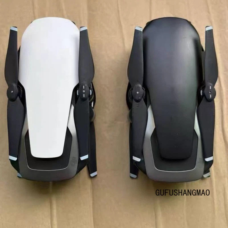 Two foldable camera drones, white and black bodies with prop arms