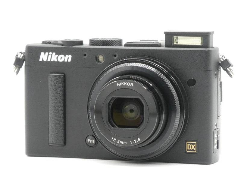 Black compact digital camera with NIKKOR lens and DX mark