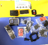 Compact black action camera with multiple mounts, waterproof case, and accessory parts