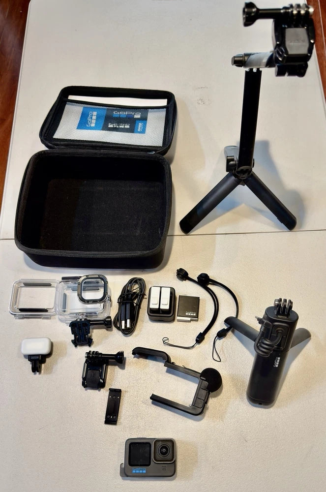 Black action camera kit with case, mounts, tripod, and handle accessories