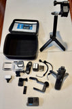 Black action camera kit with case, mounts, tripod, and handle accessories
