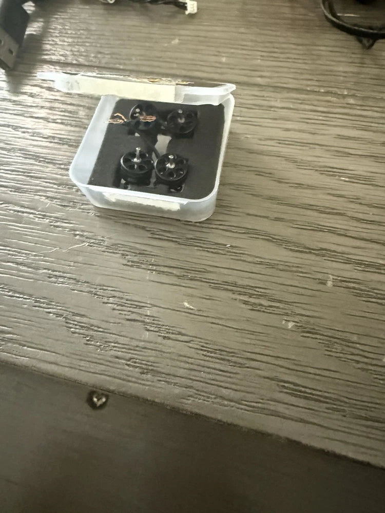 Mini quadcopter drone motor assembly in clear plastic case with four propellers