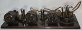 Vintage breadboard radio chassis with four vacuum tubes and knobs, dark metal base