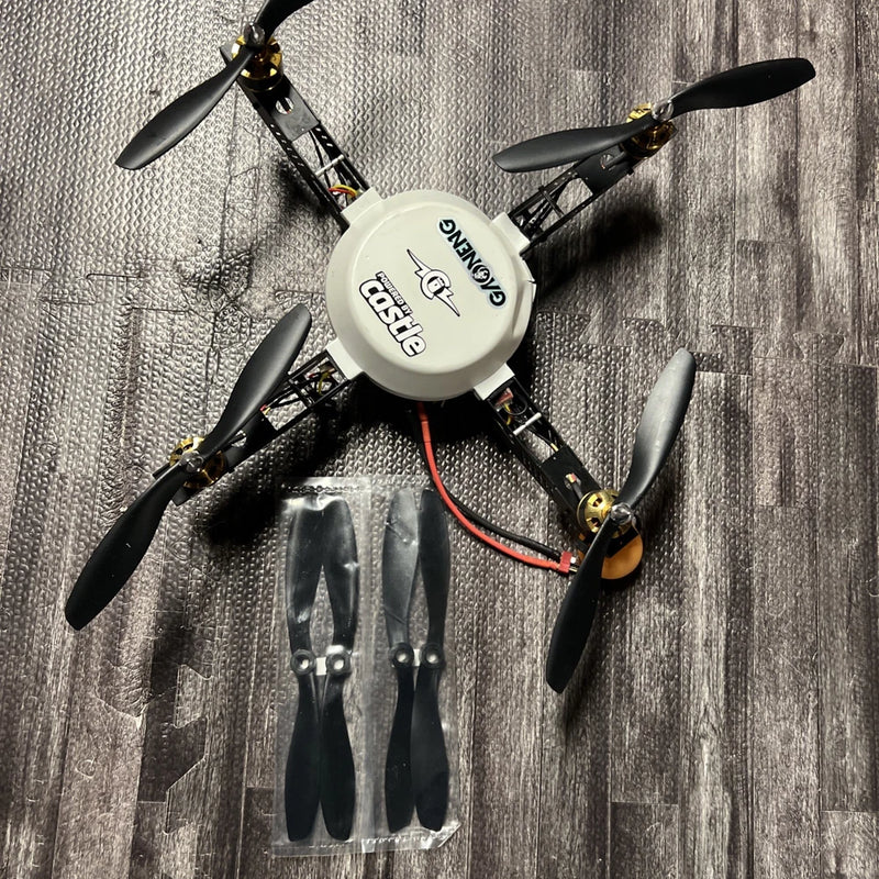 Quadcopter RC drone with four black propellers and circular white center frame