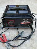 Schumacher battery extender charger with cables and red/black clamps, dark casing