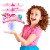 Pink flying unicorn RC toy with clear spinning propeller, held by a child