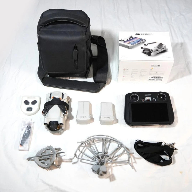 Dji Mini 3 Pro drone kit with black carry bag, remote, spare parts and props