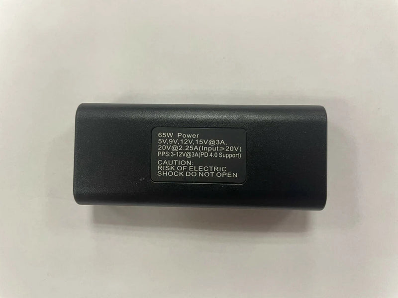Black DC to USB-C power adapter with printed 65W specifications label