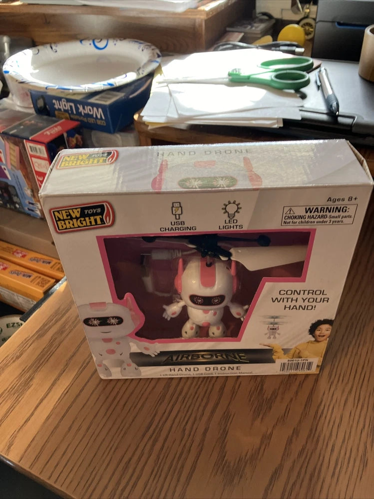 Pink hand-controlled drone toy in retail box, USB charging and LED lights