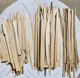 Assorted light wood balsa airplane model pieces and strips, unassembled