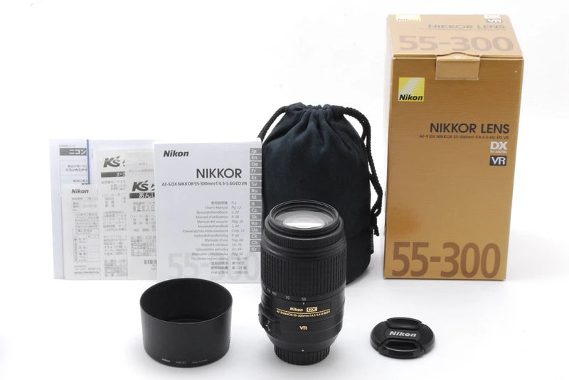 Black Nikon 55-300mm DX VR telephoto zoom lens with lens cap and case