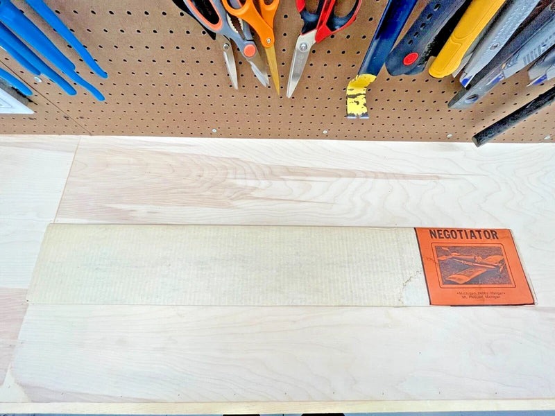 Wood board with orange "NEGOTIATOR" label