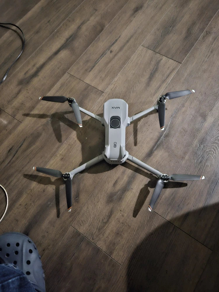 White quadcopter drone with front camera module and four propellers