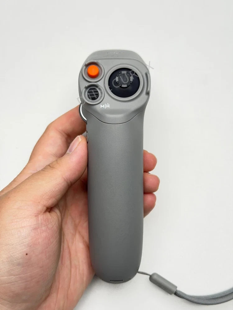 DJI RC Motion 2 motion controller, gray handheld with orange button and strap