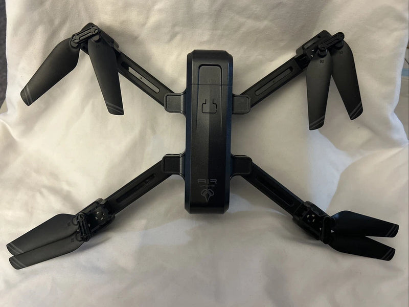 Folding black quadcopter drone with four propeller arms and central body