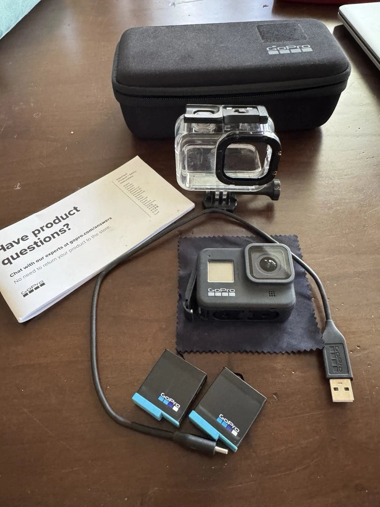 GoPro action camera with clear housing, USB cable, and two battery packs