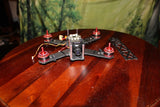 LUMENIER racing drone with compact frame and central camera, four red prop motors