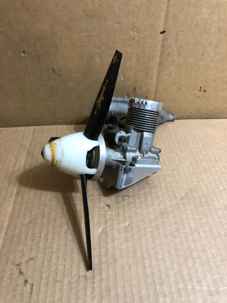 OS MAX 60 model airplane engine with muffler and white exhaust cone