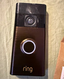 Bronze Ring battery doorbell with camera lens and front circular button