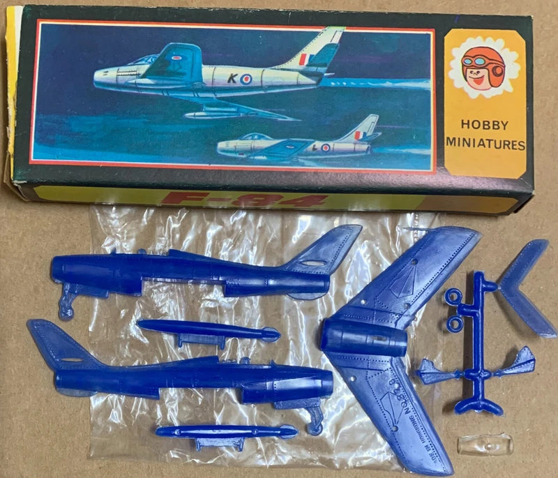 Blue plastic F84 mini plane model kit parts, fuselage and wings in blister pack