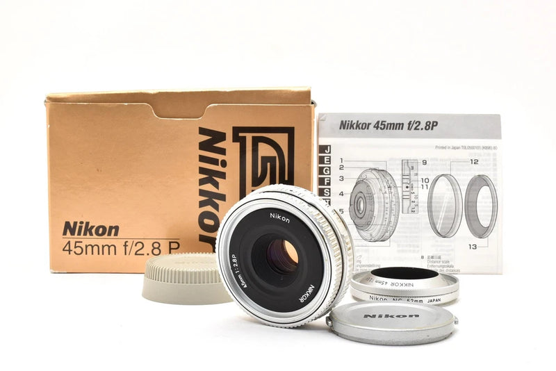 Nikon 45mm f/2.8 P MF camera lens with front cap, box, and instruction sheet