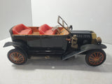 Vintage Ford Model T tin battery-operated toy car with open red seats, orange spoked wheels