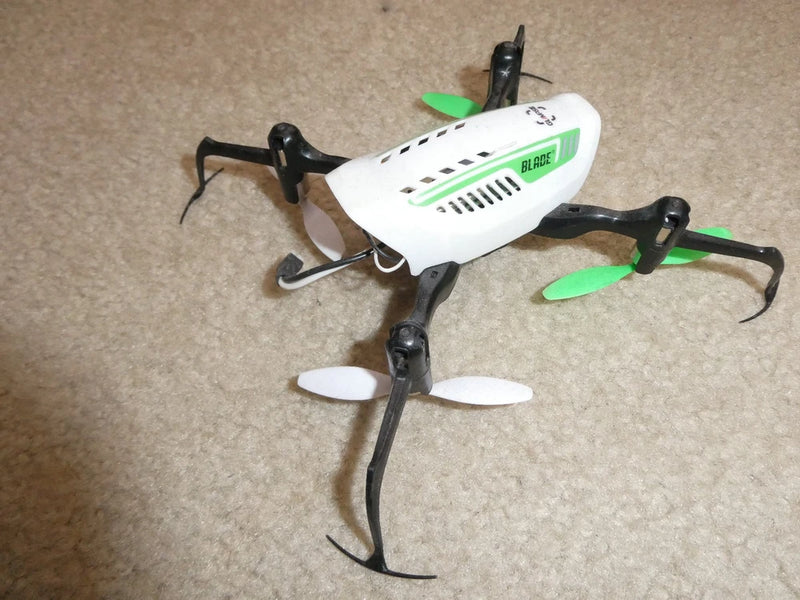 White and black nano quadcopter drone with green propellers