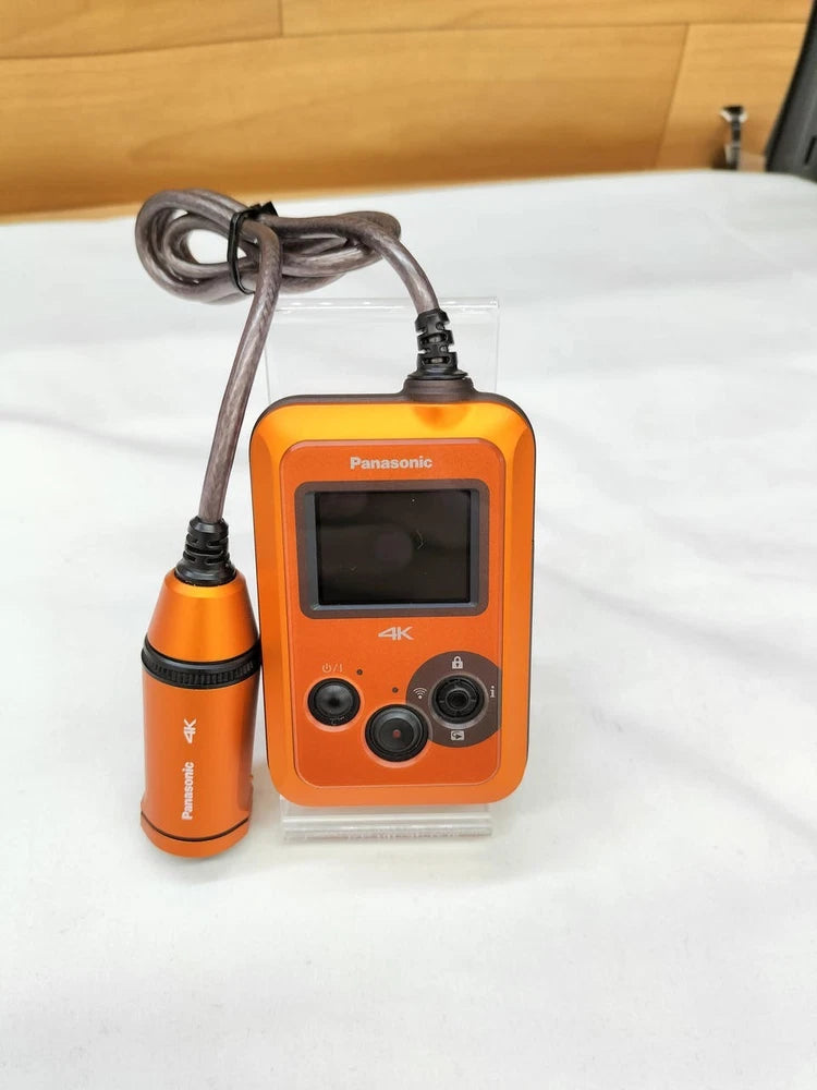 Orange Panasonic HX-A500 4K wearable POV camcorder with front LCD and controls