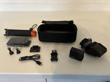 Black action camera accessory kit with carrying case, mounts, and charging/electronics
