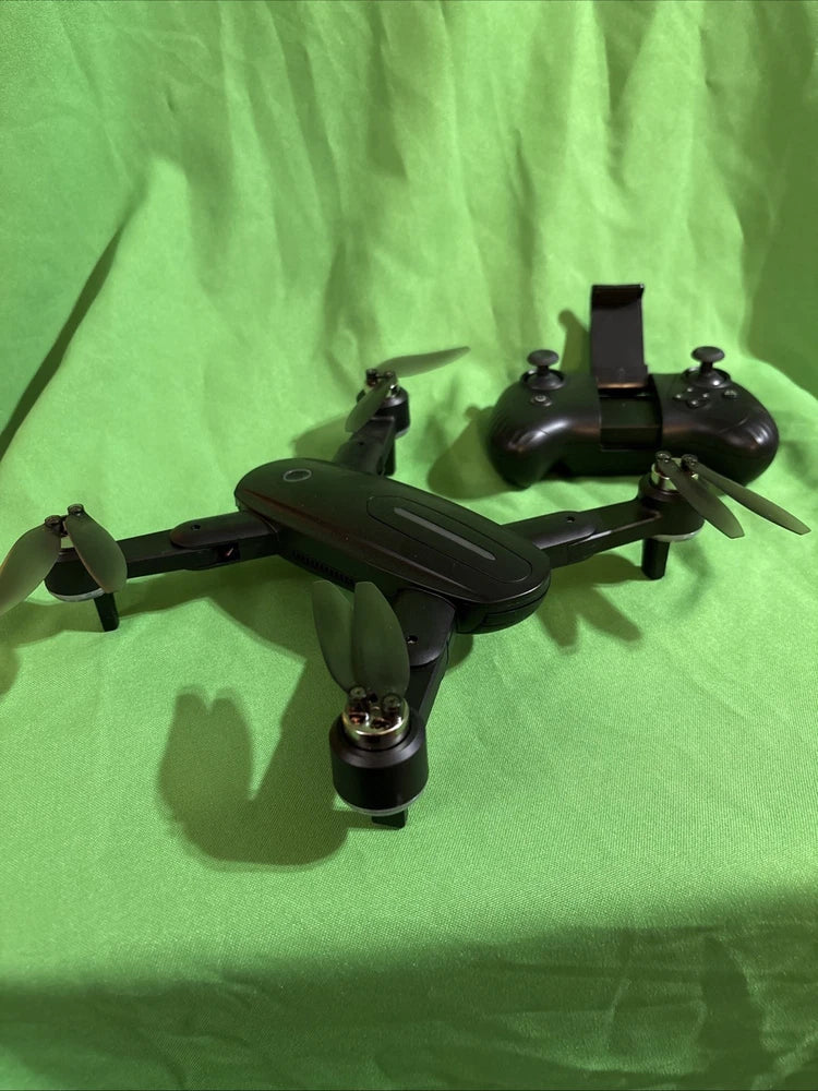 Foldable black quadcopter drone with camera, four propellers and extended landing gear