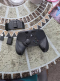Black game controller with dual thumbsticks, D-pad, and action buttons