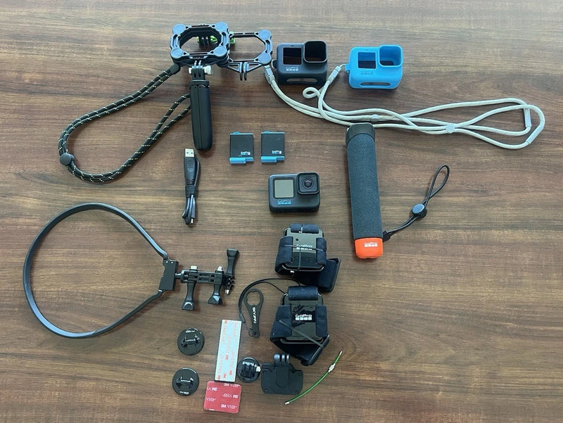 GoPro HERO10 Black action camera accessory kit with camera, mounts, cables, and handle