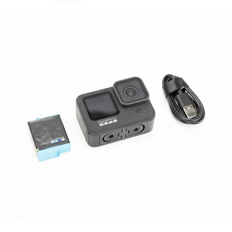 Black GoPro action camera with front screen, plus USB cable and microSD card.