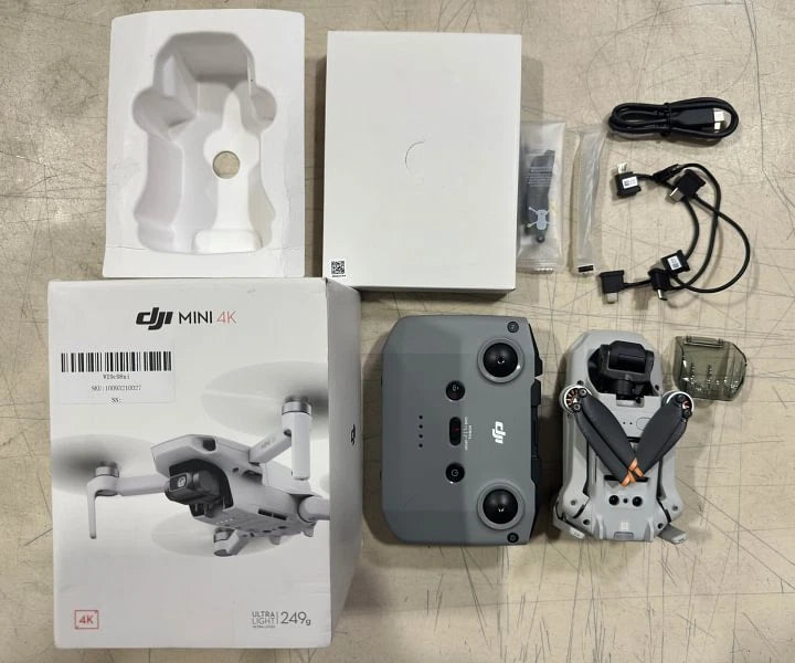Folding quadcopter drone kit with remote controller and battery, plus accessories in box