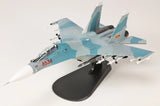 1/72 scale blue-and-white fighter jet model on dark display stand, side view.