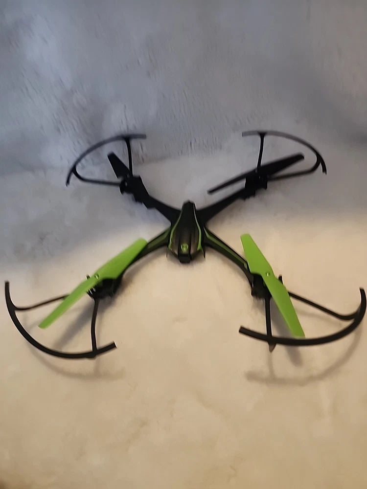 Green quadcopter stunt drone with four black propellers, for parts