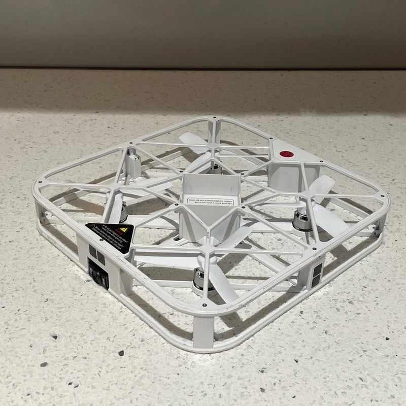 White quadcopter drone with four rotors and mounted camera