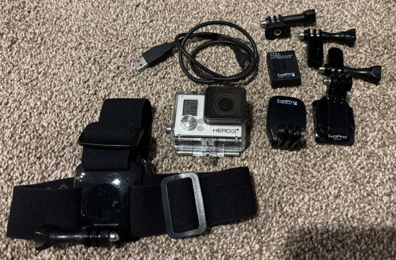 Silver action camera kit with mounts, cables, and waterproof housing