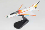 White and orange fighter jet model on black display stand, side view.