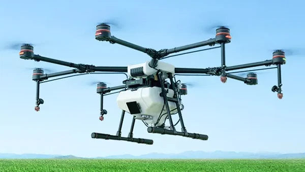 Agricultural spraying drone with multi-rotor arms and spray nozzles mounted underneath
