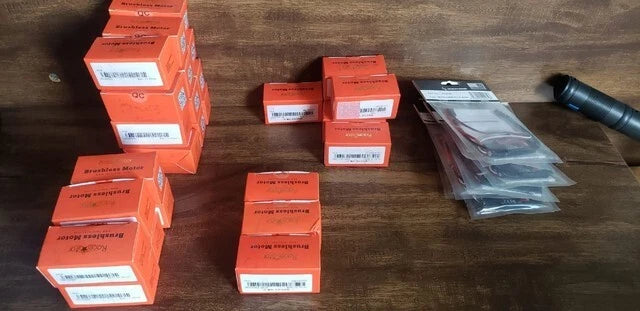 RC motor and ESC kit with orange boxes and plastic-wrapped components