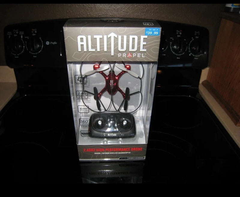 Propel Altitude quadcopter drone retail package, red-and-black drone and remote controller