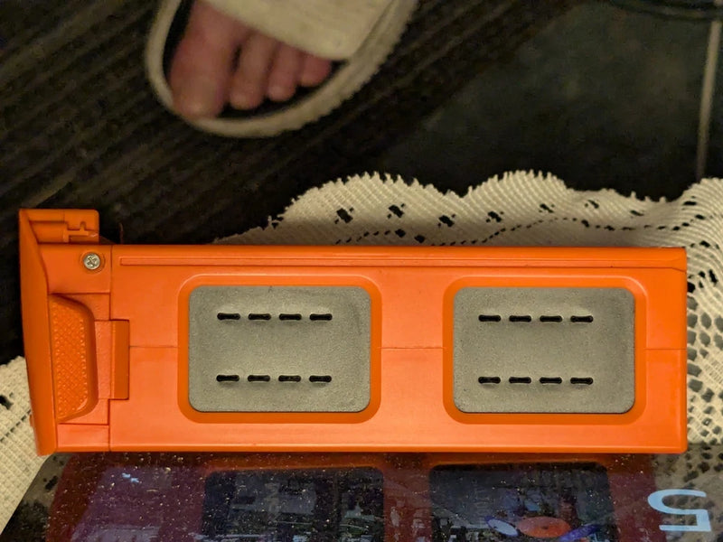 Orange flight battery pack with two sets of charging contacts and connectors