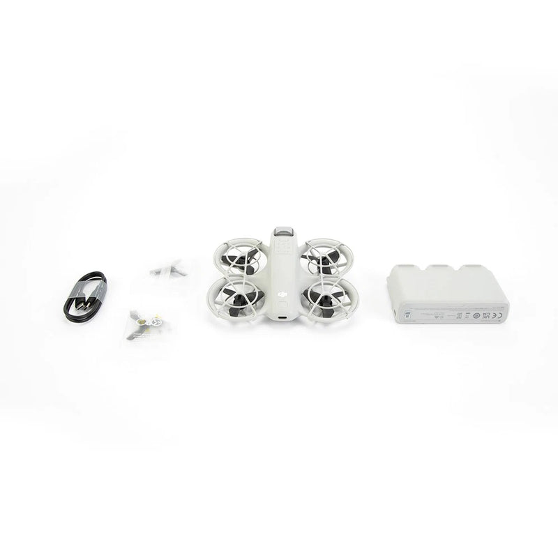White quadcopter drone with four propellers, spare parts and battery charger