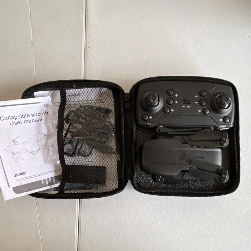 Foldable quadcopter drone in black carrying case with remote and folded prop arms