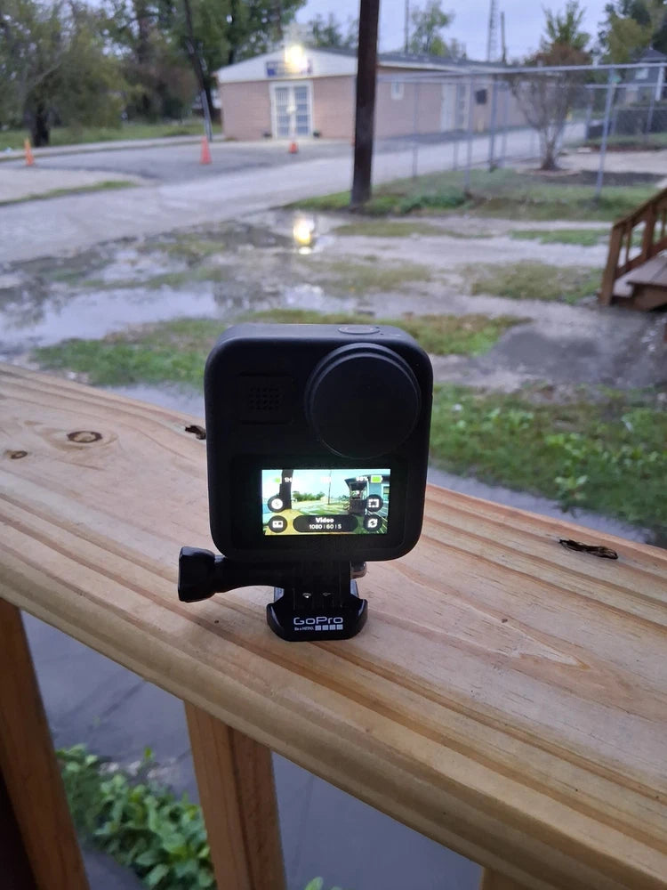Black action camera on a mount with a lit LCD screen